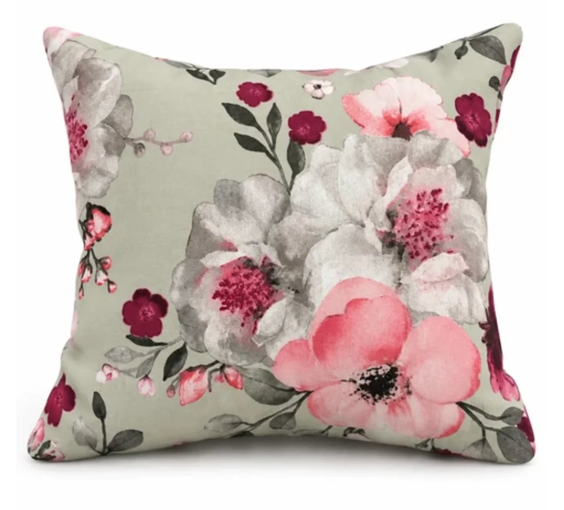 Decorative throw pillow with floral pattern featuring pink, white, and burgundy flowers on cream background
